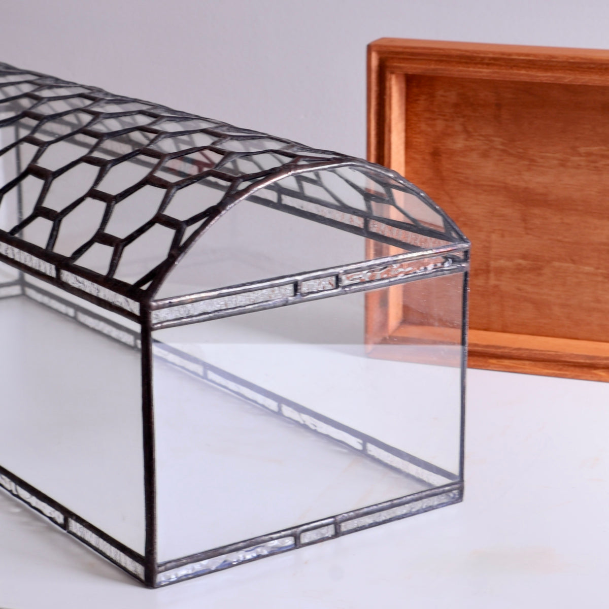 Glass box with geometric patterned lid on a white surface