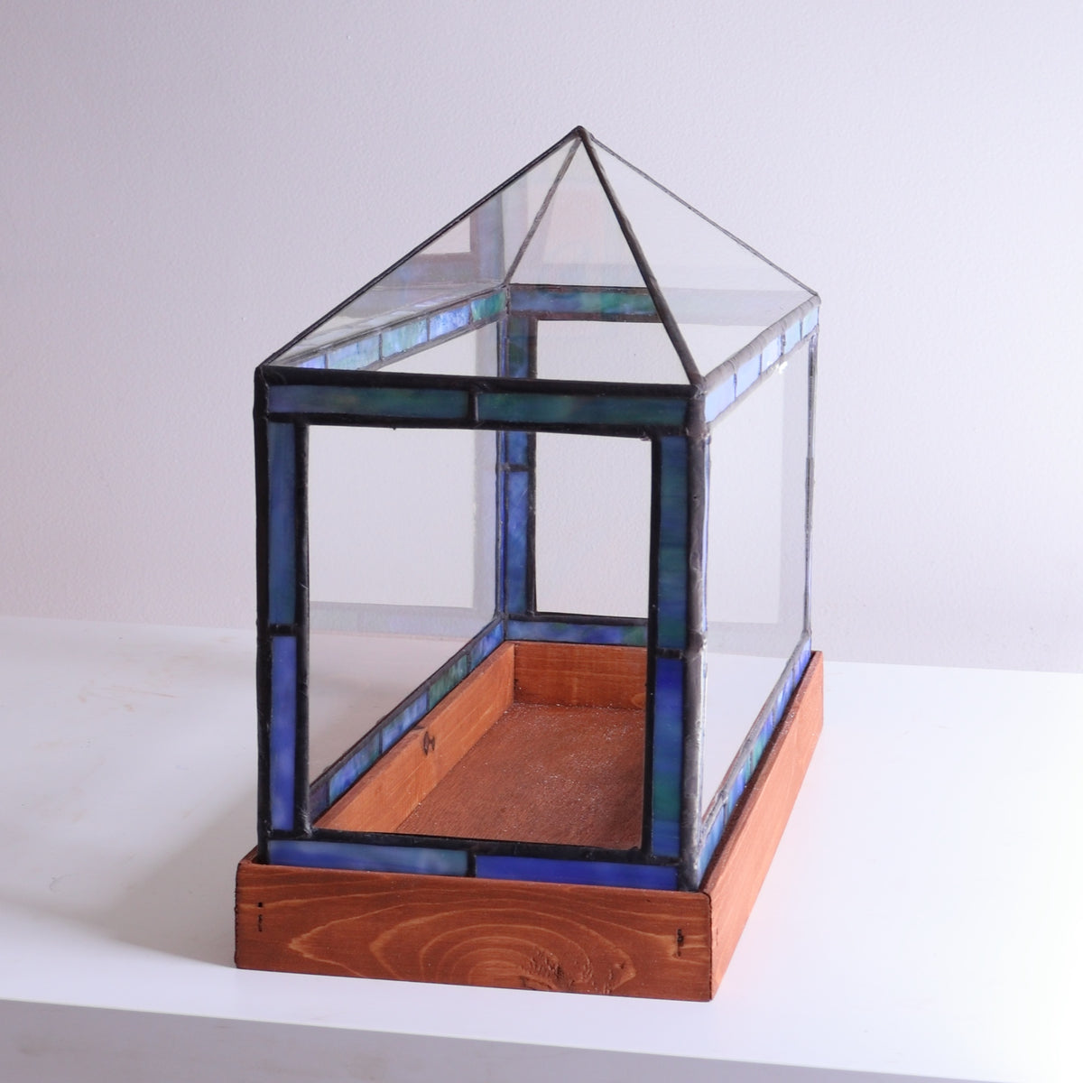 Glass terrarium with stained glass top on a white background