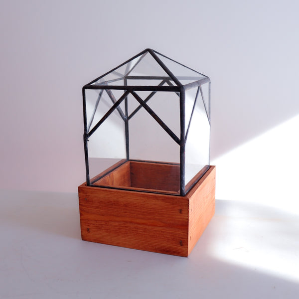A handmade terrarium on a wood base. Stained glass. 