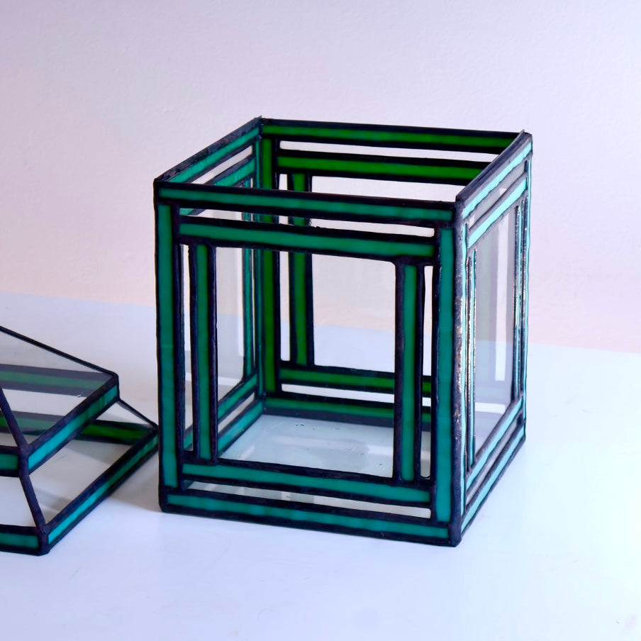 Stained-glass terrarium with green glass frames on a white background