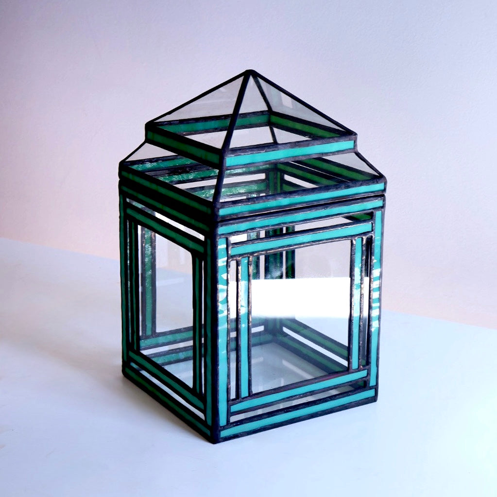 Glass terrarium with greenish tint on a white background